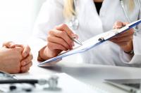 Female doctor writing on a clipboard